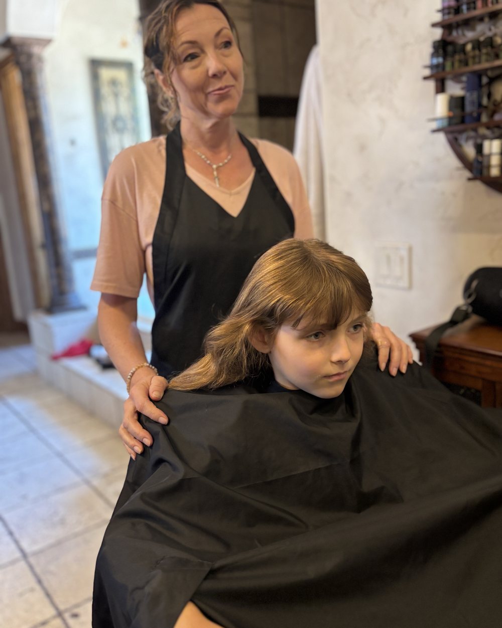 Getting a young client caped and settled in before a long-hair cut.